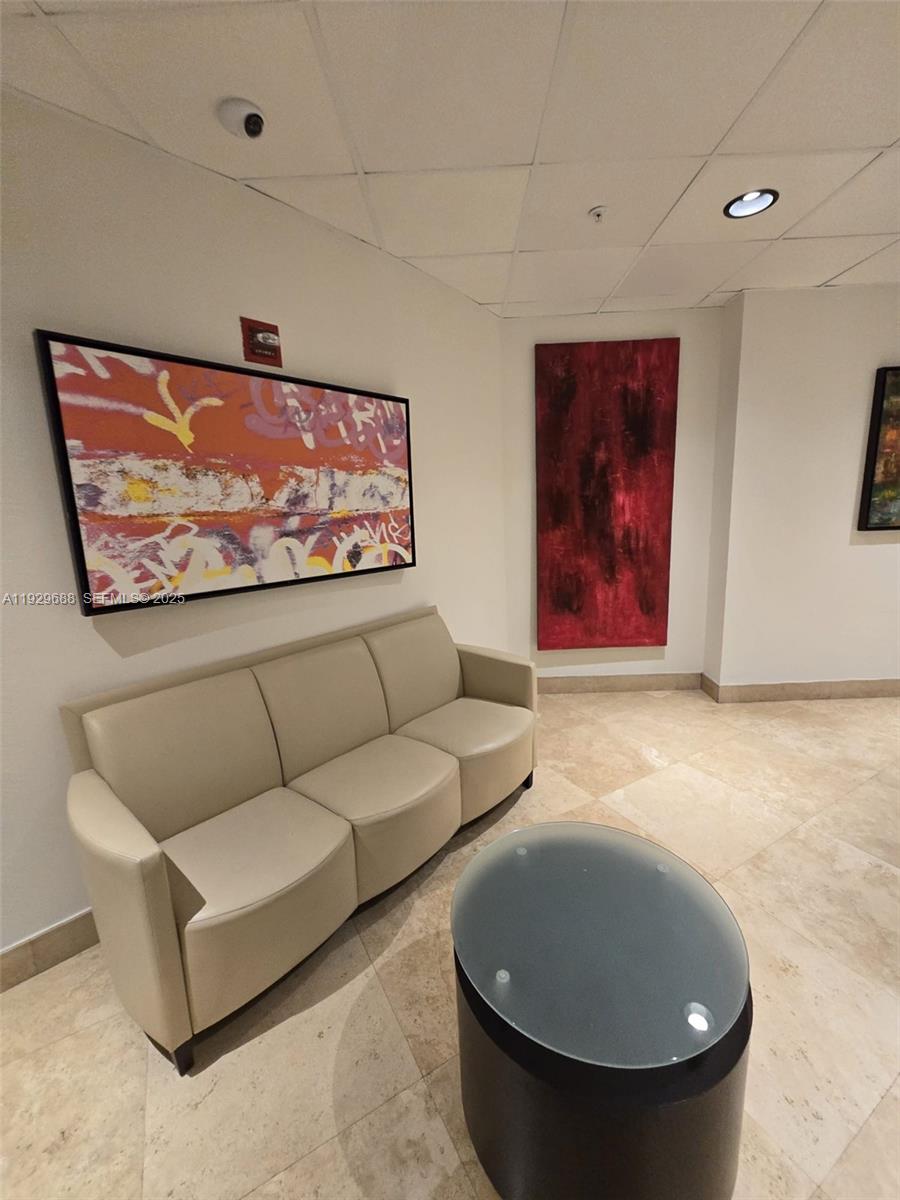 A waiting area features a beige sofa, a glass-topped table, and two pieces of wall art — 1500 Bay Rd # 1178S, Miami Beach FL 33139, MIAMI BEACH, FL