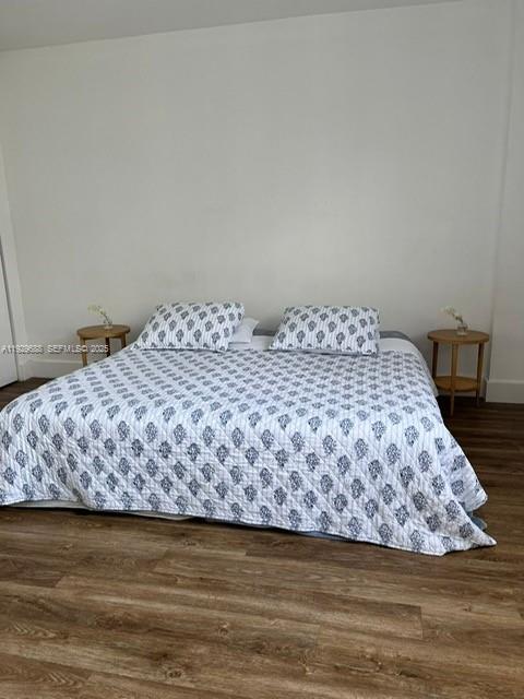 A bedroom features a bed with a patterned quilt and two small wooden side tables — 1500 Bay Rd # 1178S, Miami Beach FL 33139, MIAMI BEACH, FL