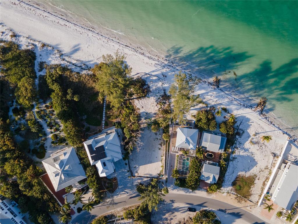 Aerial view of two beachfront houses with metal roofs and a pool near the ocean — 831 NORTH SHORE DRIVE, ANNA MARIA, FL