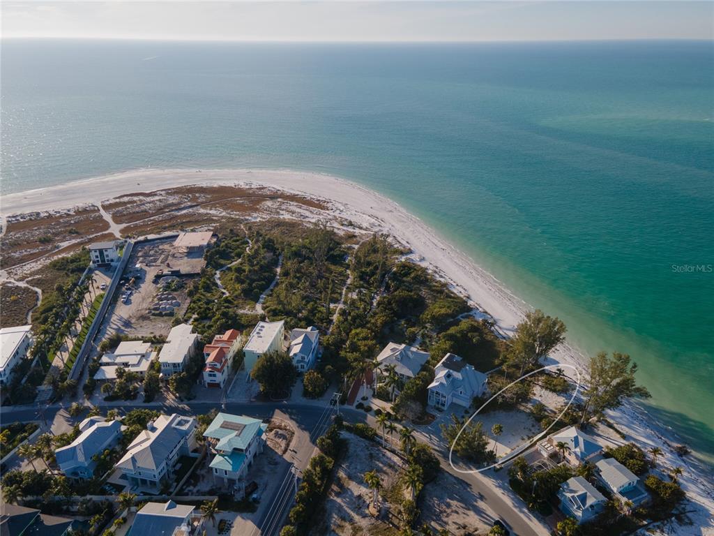 An aerial view shows a coastal neighborhood with a vacant lot circled near the beach — 831 NORTH SHORE DRIVE, ANNA MARIA, FL