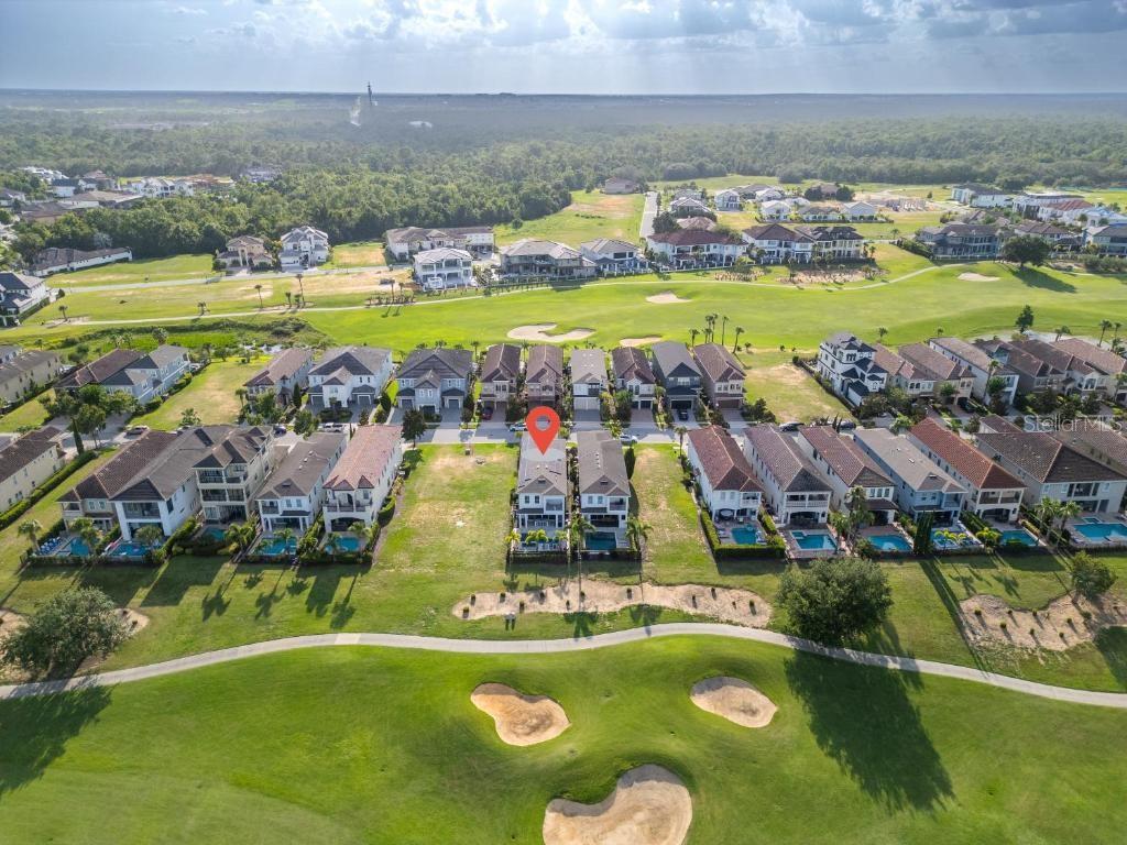 An aerial view shows a row of suburban houses bordering a golf course — 1117 CASTLE PINES COURT, REUNION, FL