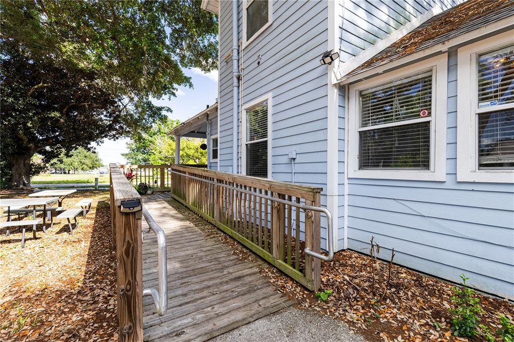 A two-story light blue house features a wrap-around porch and a wooden deck — 1320 JERSEY AVENUE, ST CLOUD, FL