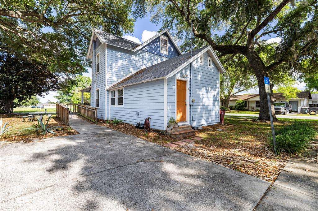 A light blue two-story house with a wooden wheelchair ramp and a concrete driveway — 1320 JERSEY AVENUE, ST CLOUD, FL