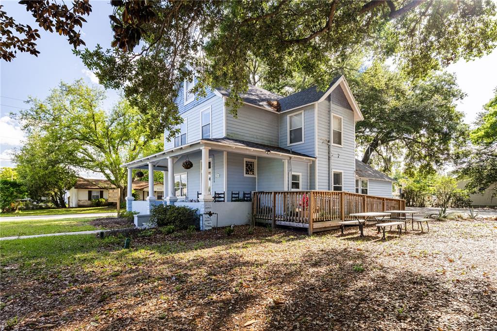 A wooden wheelchair ramp leads up to the side of a light blue house — 1320 JERSEY AVENUE, ST CLOUD, FL