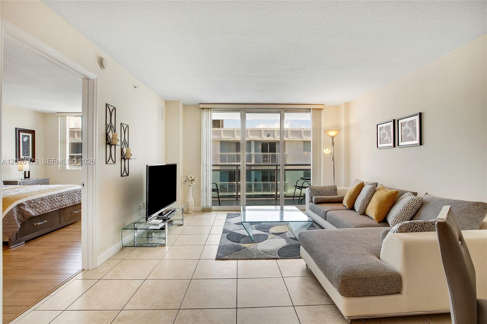 A living room with tile floors, a sectional sofa, and a glass coffee table — 6917 Collins Ave # 1608, Miami Beach FL 33141, MIAMI BEACH, FL