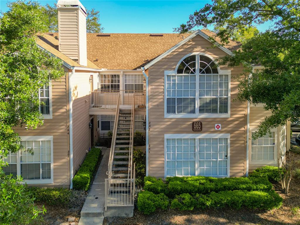 A two-story tan apartment building features a central metal staircase and large arched windows — 665 YOUNGSTOWN PARKWAY UNIT 262, ALTAMONTE SPRINGS, FL