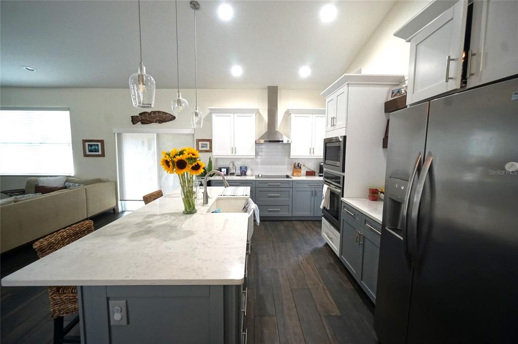 A kitchen features a large island, gray lower cabinets, white upper cabinets, and stainless appliances — 2314 W SAINT SOPHIA STREET, TAMPA, FL
