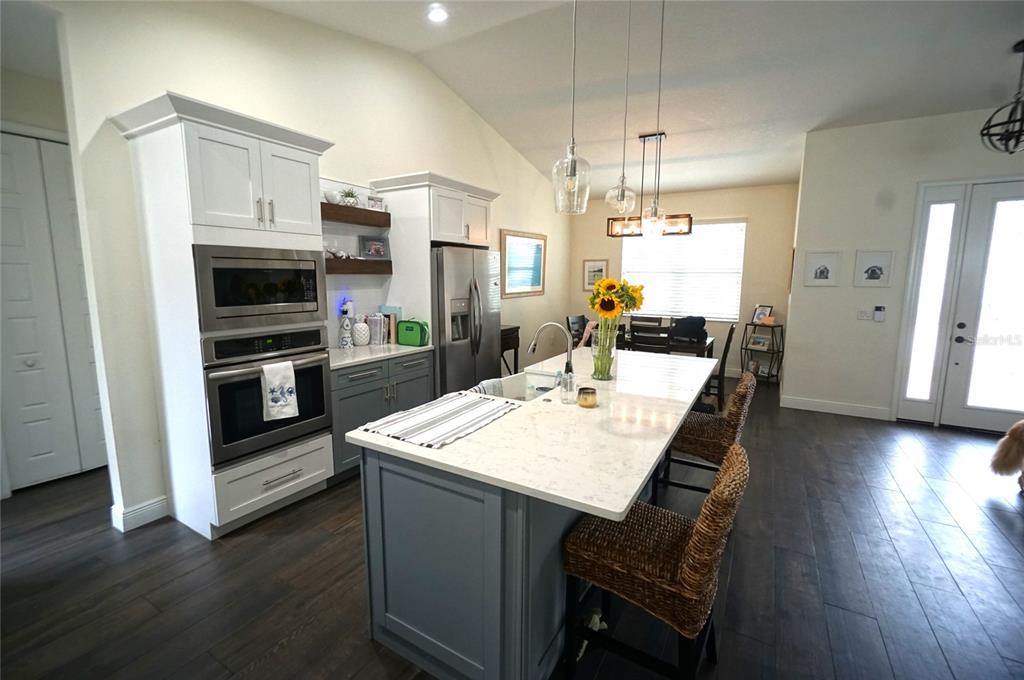 A kitchen features a large island with bar seating, white cabinetry, and stainless steel appliances — 2314 W SAINT SOPHIA STREET, TAMPA, FL