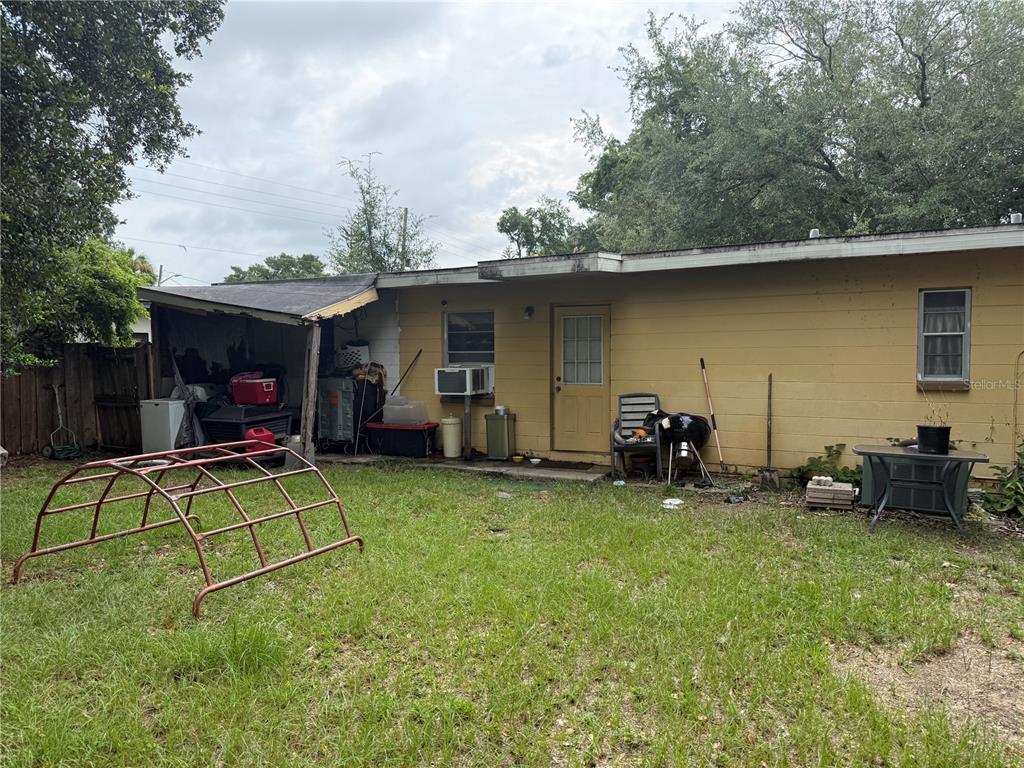 The exterior of a yellow house features a small covered patio and a grassy yard — 4108 DELRAY AVENUE, ORLANDO, FL