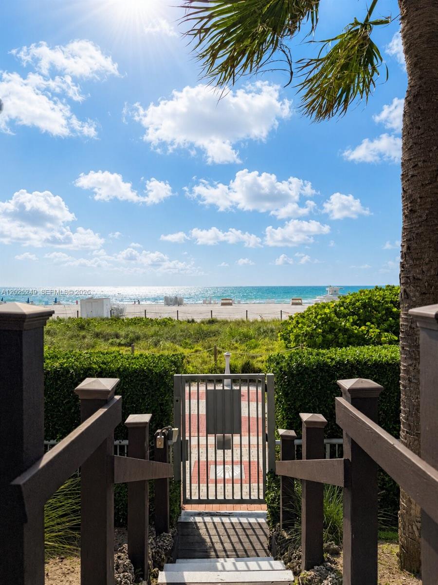 A wooden staircase leads down to a gated path overlooking a beach and the ocean — 3737 Collins Ave # 1003, Miami Beach FL 33140, MIAMI BEACH, FL