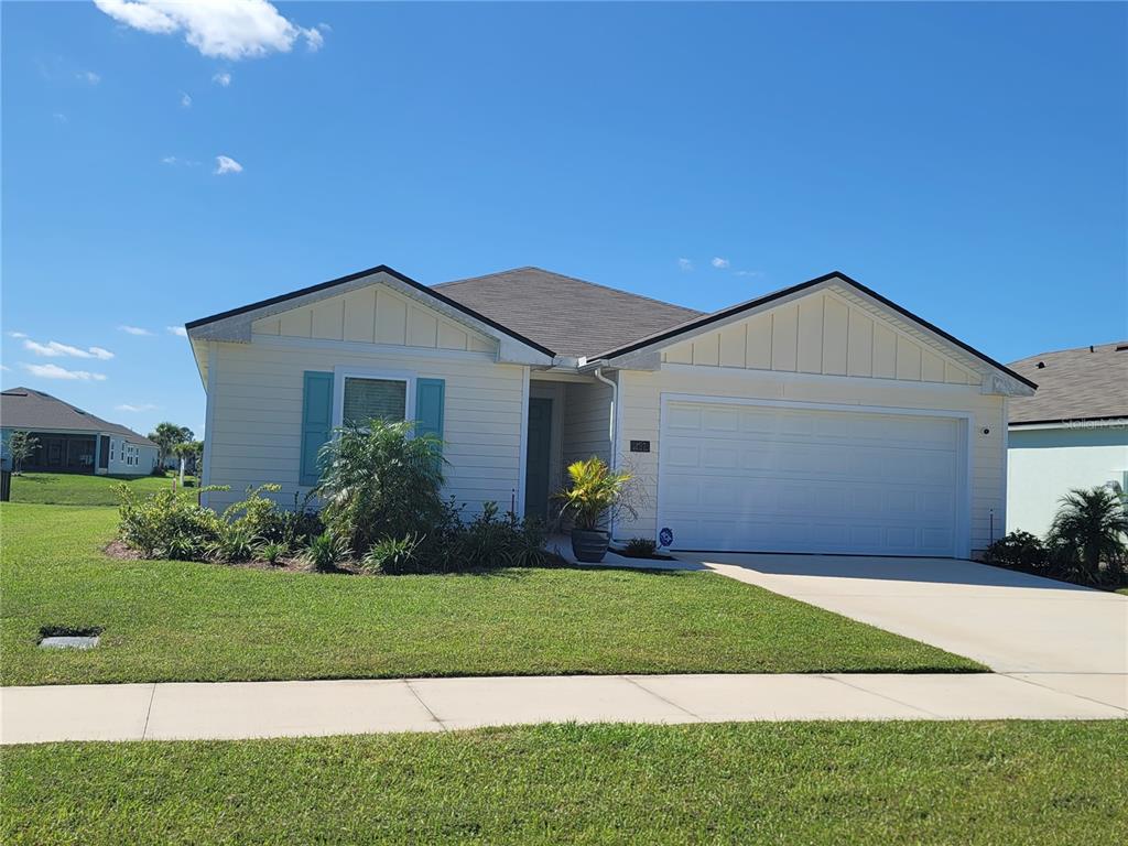 A single-story house with light yellow siding, a two-car garage, and a front lawn — 127 HULETT WOODS ROAD, PALM COAST, FL