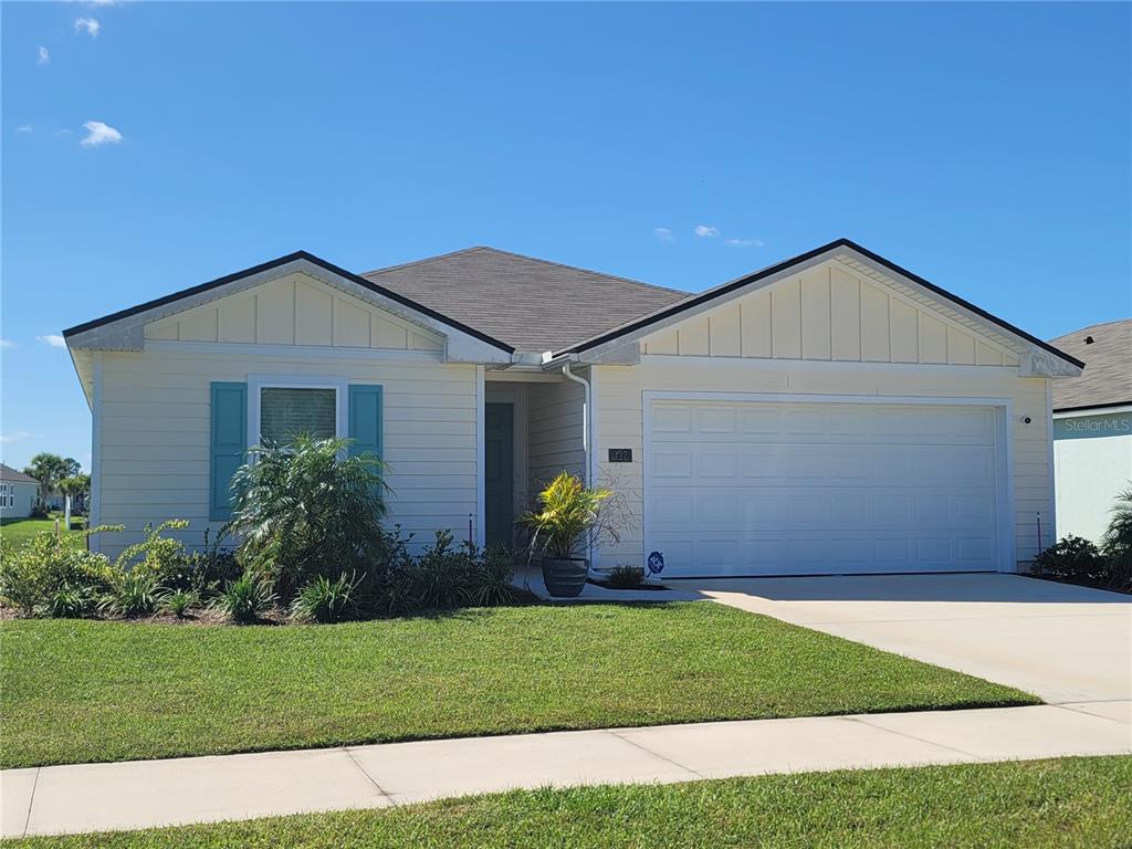 A single-story house with light yellow siding, a two-car garage, and blue window shutters — 127 HULETT WOODS ROAD, PALM COAST, FL
