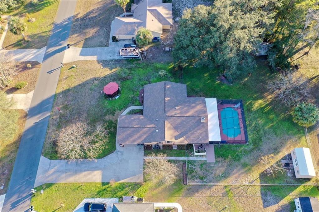 An aerial view shows a house with a pool, a gazebo, and a detached shed — 3002 S ROSE AVENUE, INVERNESS, FL