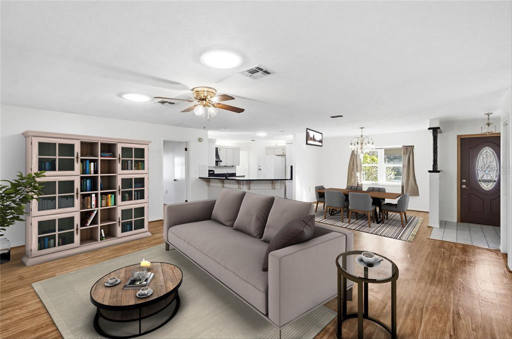 This is a digitally staged living and dining area with wood-look flooring and white walls — 3002 S ROSE AVENUE, INVERNESS, FL