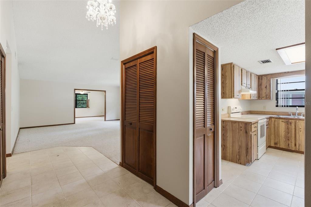 A tiled entryway leads to a carpeted living area and a kitchen with wood cabinets — 30 RAMBLEWOOD TRAIL, DELAND, FL