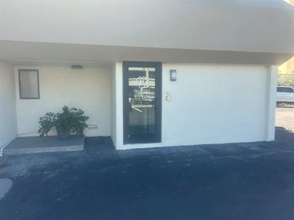 An exterior view of a building entrance with a glass door and a small plant — 2063 MAIN STREET UNIT 102, SARASOTA, FL