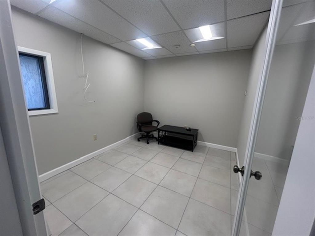 A small office with light gray walls, white trim, tiled floors, and a drop ceiling — 2063 MAIN STREET UNIT 102, SARASOTA, FL