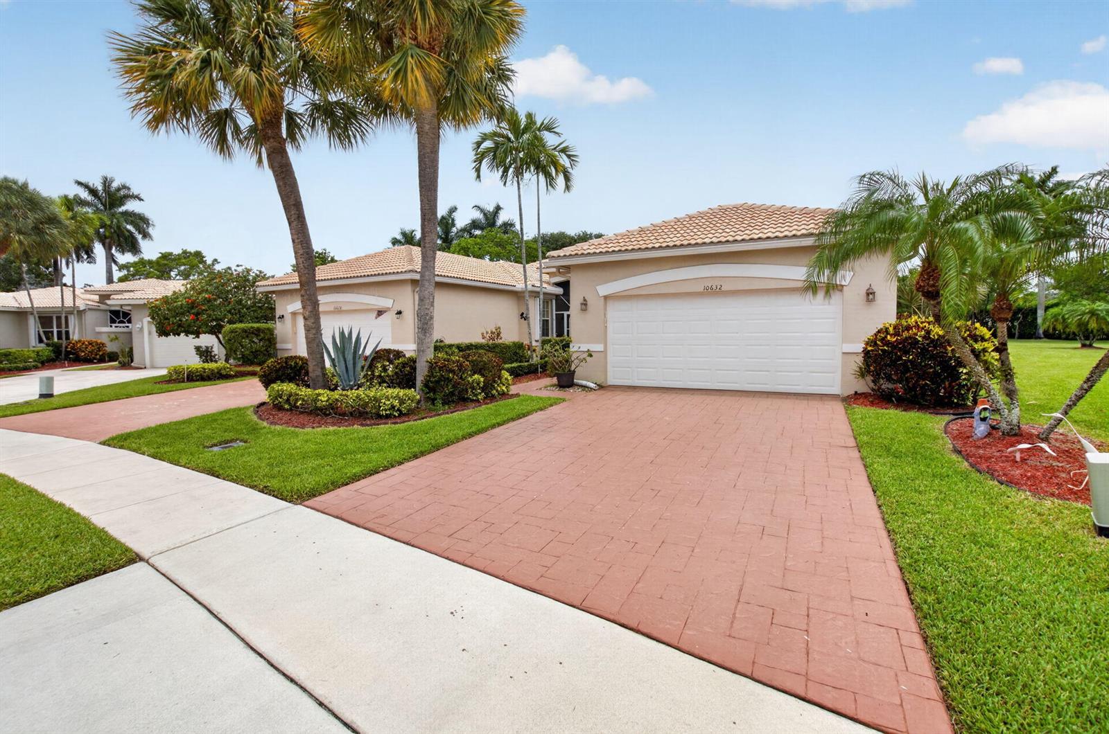 A single-story house with a white garage door, a paved driveway, and palm trees — 10632 Royal Caribbean Circle, Boynton Beach FL 33437, BOYNTON BEACH, FL