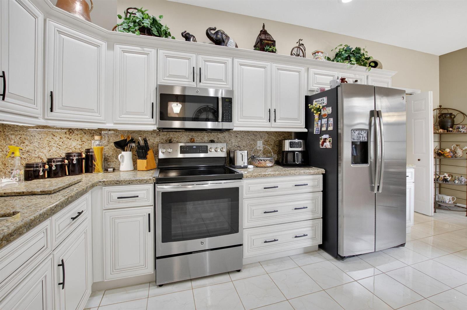 A kitchen with white cabinets, stainless steel appliances, and granite countertops — 10632 Royal Caribbean Circle, Boynton Beach FL 33437, BOYNTON BEACH, FL