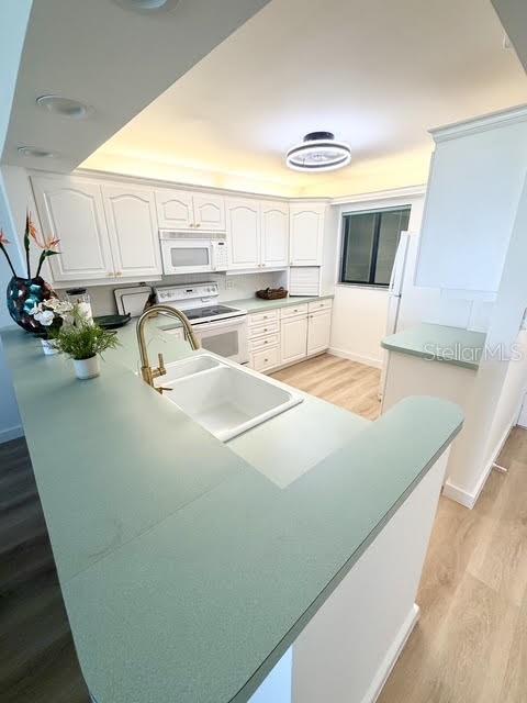 A kitchen features white cabinets, a light green countertop, and a white sink — 865 S GULFVIEW BOULEVARD UNIT 202, CLEARWATER BEACH, FL