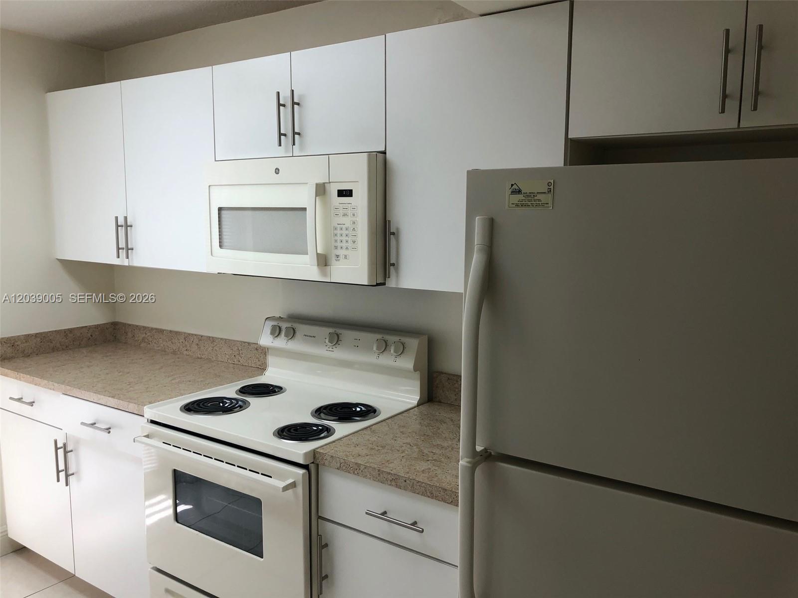 A kitchen features white cabinets, a white stove, a microwave, and a white refrigerator — 10808 N Kendall Dr # 4, Miami FL 33176, MIAMI, FL