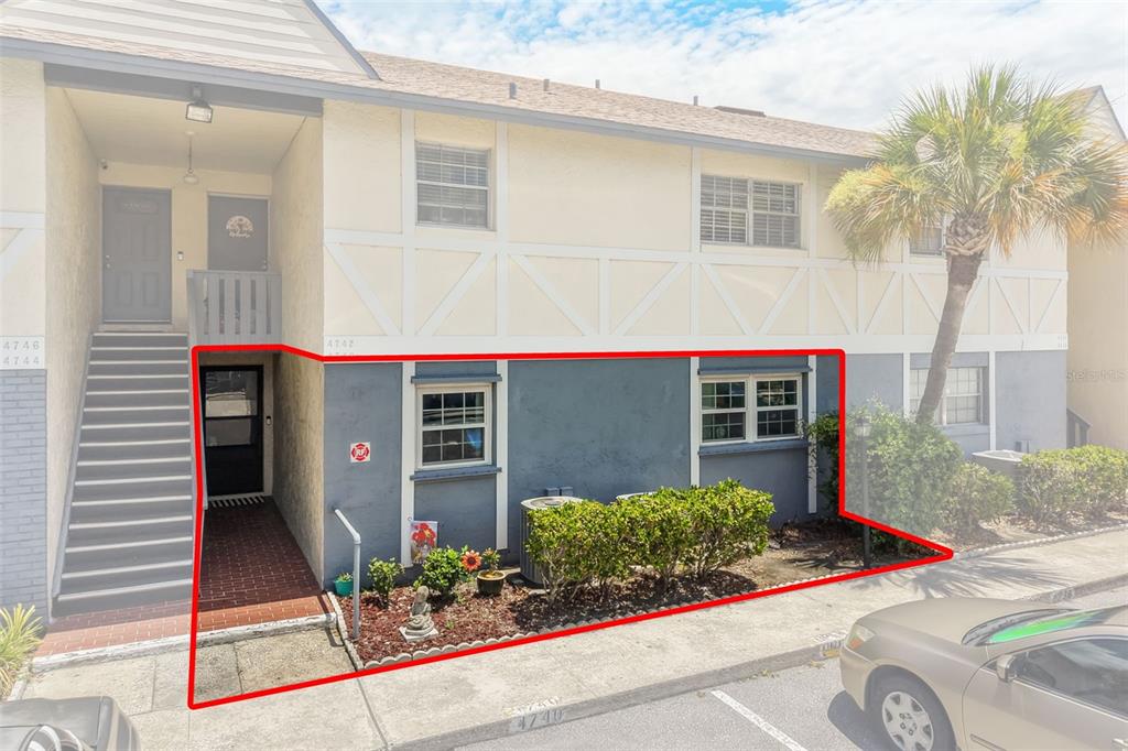 A ground-floor apartment entrance and exterior wall are highlighted in red on a building — 4740 AVON COURT UNIT 4740, ST CLOUD, FL