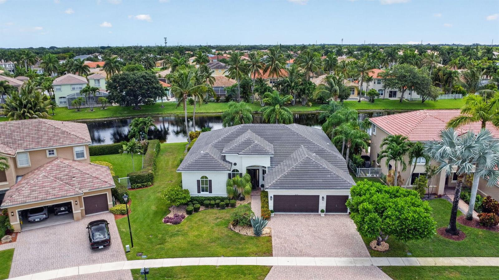 An aerial view shows a single-story suburban house with a gray tile roof and driveway — 6733 Finamore Circle, Lake Worth FL 33467, LAKE WORTH, FL