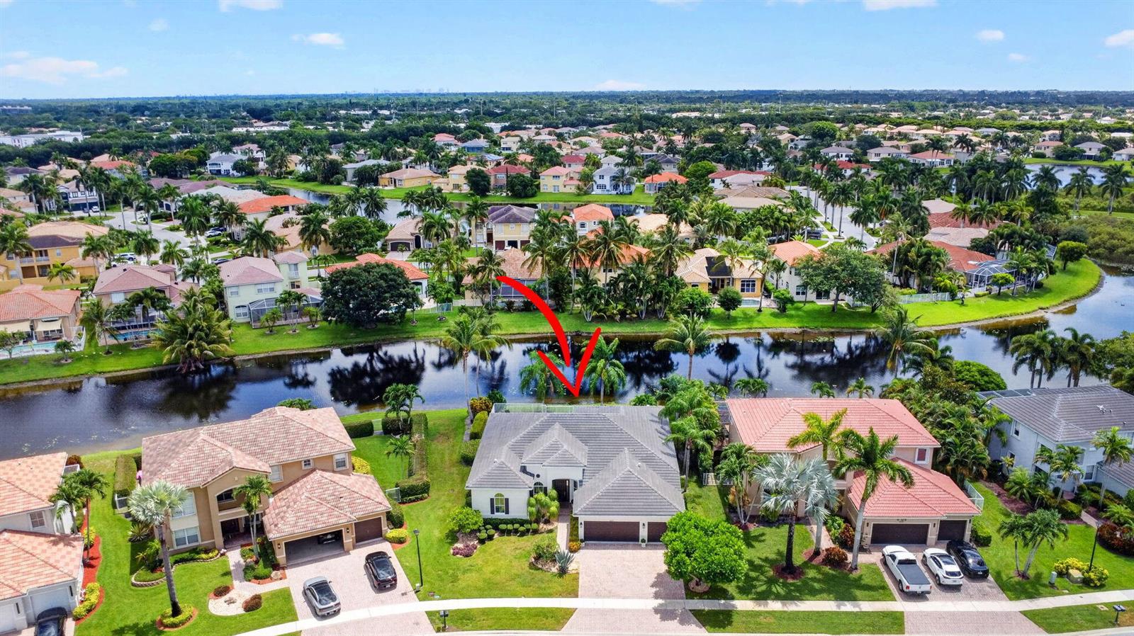 An aerial view of a suburban house with a pool and patio facing a canal — 6733 Finamore Circle, Lake Worth FL 33467, LAKE WORTH, FL
