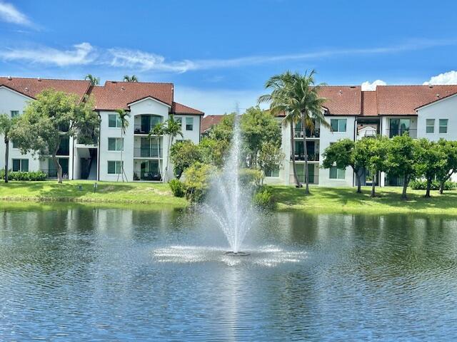 A fountain sprays water in a pond in front of two multi-story apartment buildings — 822 Villa Circle, Boynton Beach FL 33435, BOYNTON BEACH, FL