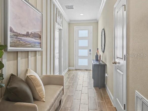 A hallway features wood-look tile floors, vertical wall paneling, a beige sofa, and a front door — TBD lot 2 JAGUST ROAD, NORTH PORT, FL