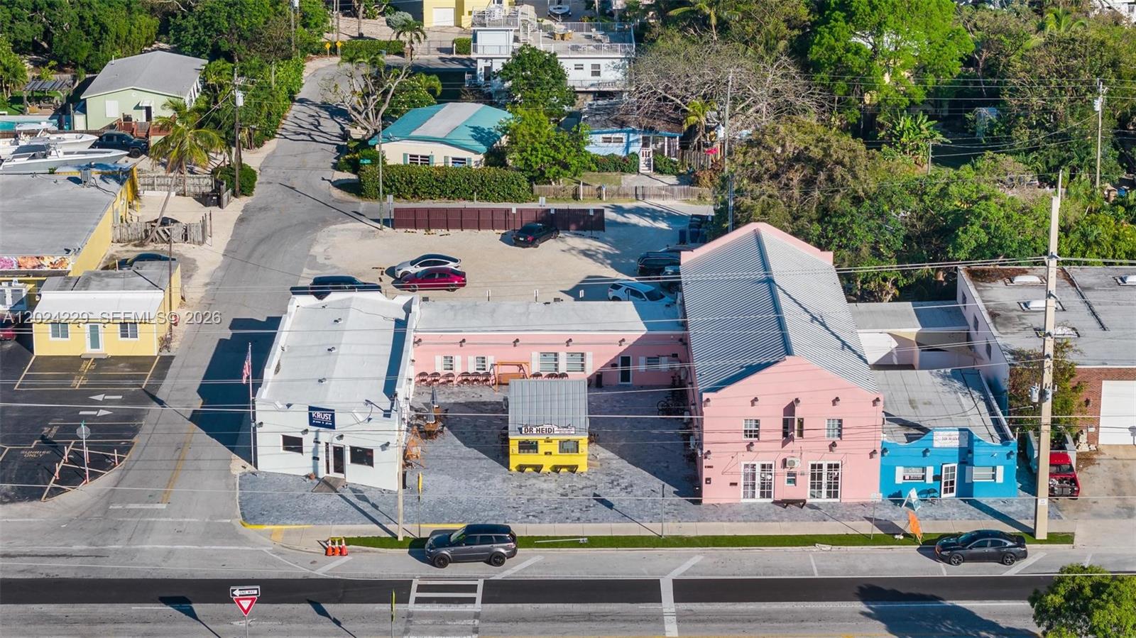 An aerial view shows a commercial property with pink and white buildings and a parking lot — 91865 Overseas Hwy, FL 33070, FL