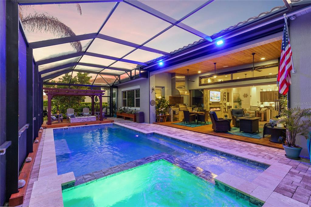 A screened-in patio features a swimming pool, a hot tub, and an outdoor kitchen area — 13391 ALDERLEY DRIVE, ORLANDO, FL