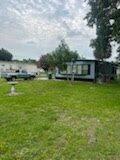 A single-story manufactured home sits on a grassy lot with a parked pickup truck nearby — 137 Imperial Way, Fort Pierce FL 34951, FORT PIERCE, FL