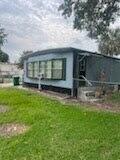 A blue mobile home exterior with a large window and a small concrete porch area — 137 Imperial Way, Fort Pierce FL 34951, FORT PIERCE, FL