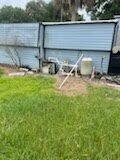 A backyard view shows a blue shed with an exposed white pipe and utility equipment — 137 Imperial Way, Fort Pierce FL 34951, FORT PIERCE, FL
