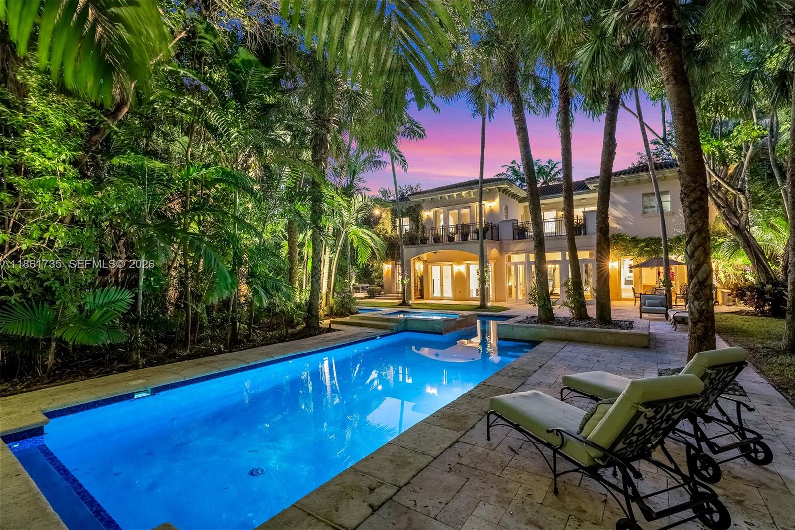 A two-story house with a pool and lounge chairs sits in a lush, palm-filled backyard — 5100 SW 86th St, Miami FL 33143, MIAMI, FL