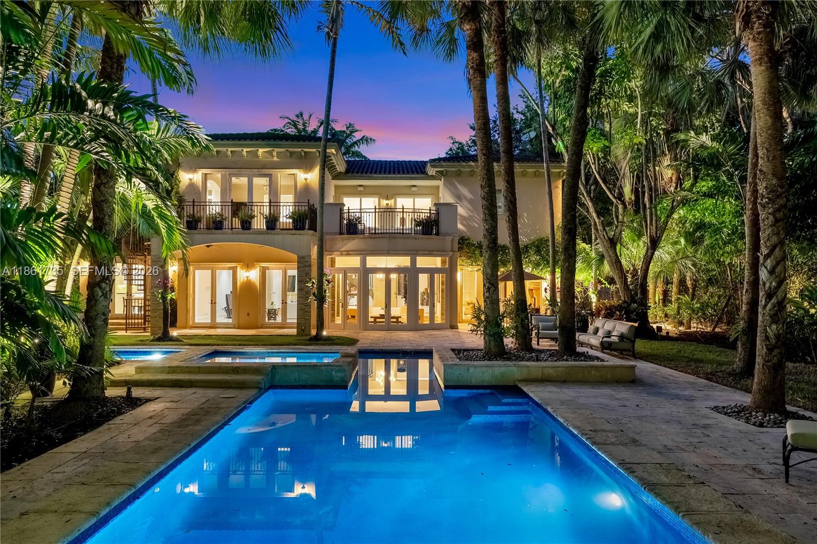 A two-story house with a pool, patio, and palm trees at dusk — 5100 SW 86th St, Miami FL 33143, MIAMI, FL