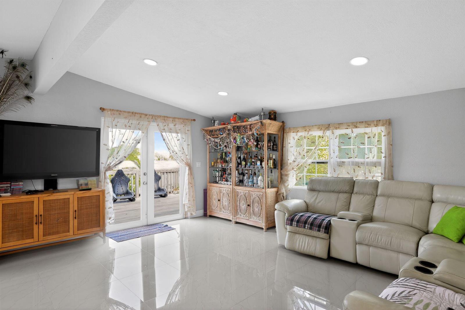 A living room features light tile floors, a white leather sectional, and a wicker cabinet — 27910 Porgie Path, FL 33042, FL