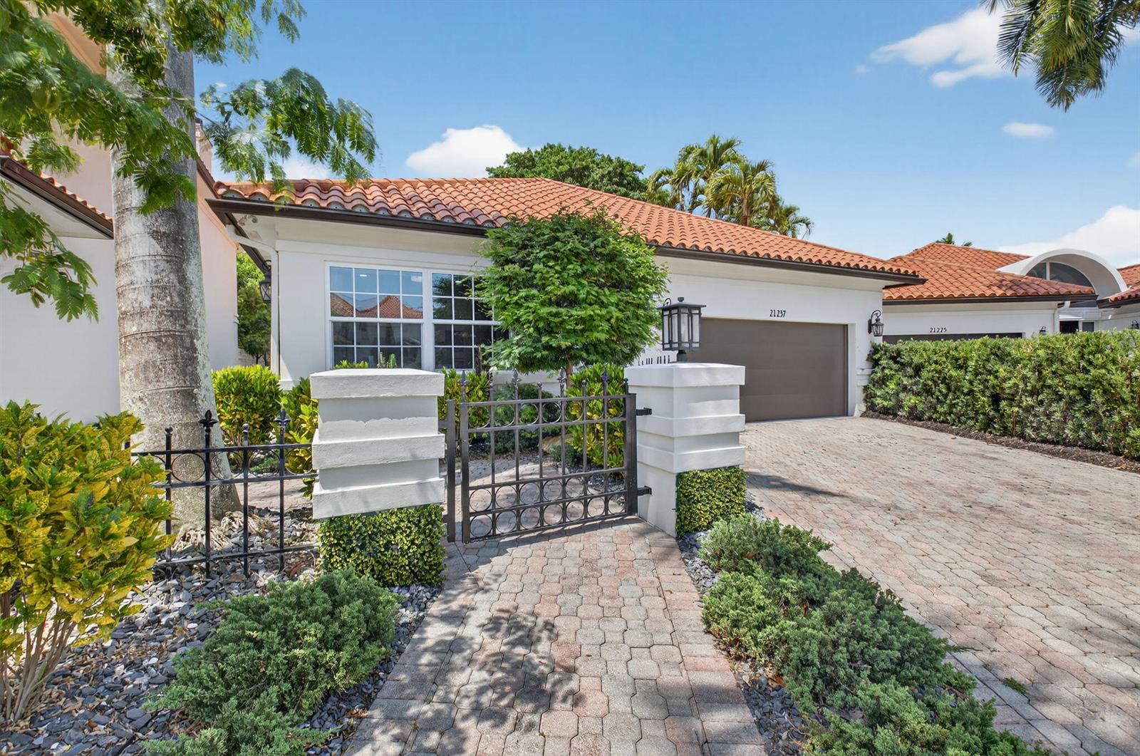 A single-story house with a tiled roof, a paved driveway, and a gated front courtyard — 21237 Harrow Court, Boca Raton FL 33433, BOCA RATON, FL