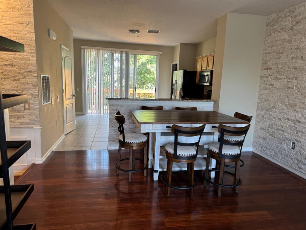 A dining area with a wooden table and stools sits in front of a kitchen counter — 3133 BAYSHORE OAKS DRIVE, TAMPA, FL