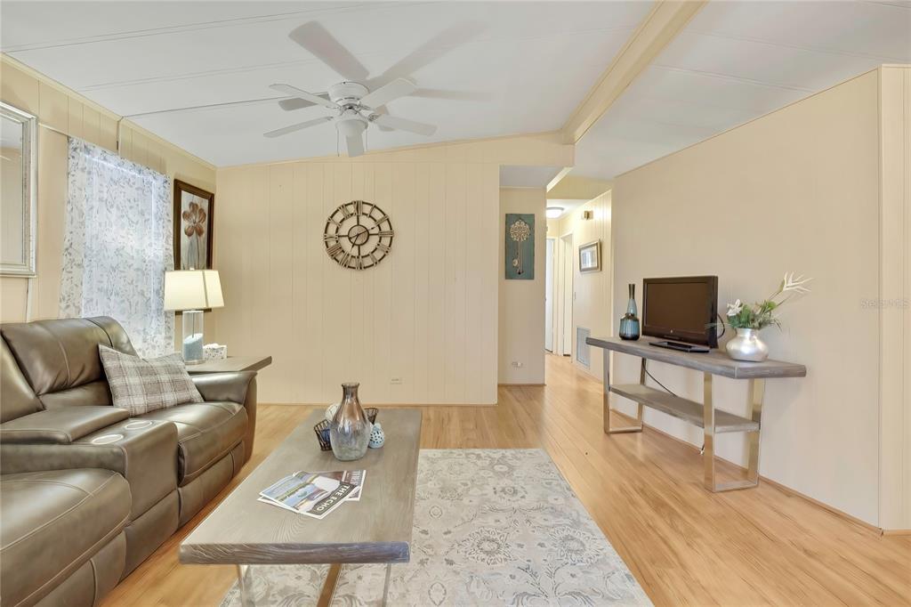 A living room features a leather sofa, a coffee table, and a television on a console — 57 N BOBWHITE ROAD, WILDWOOD, FL