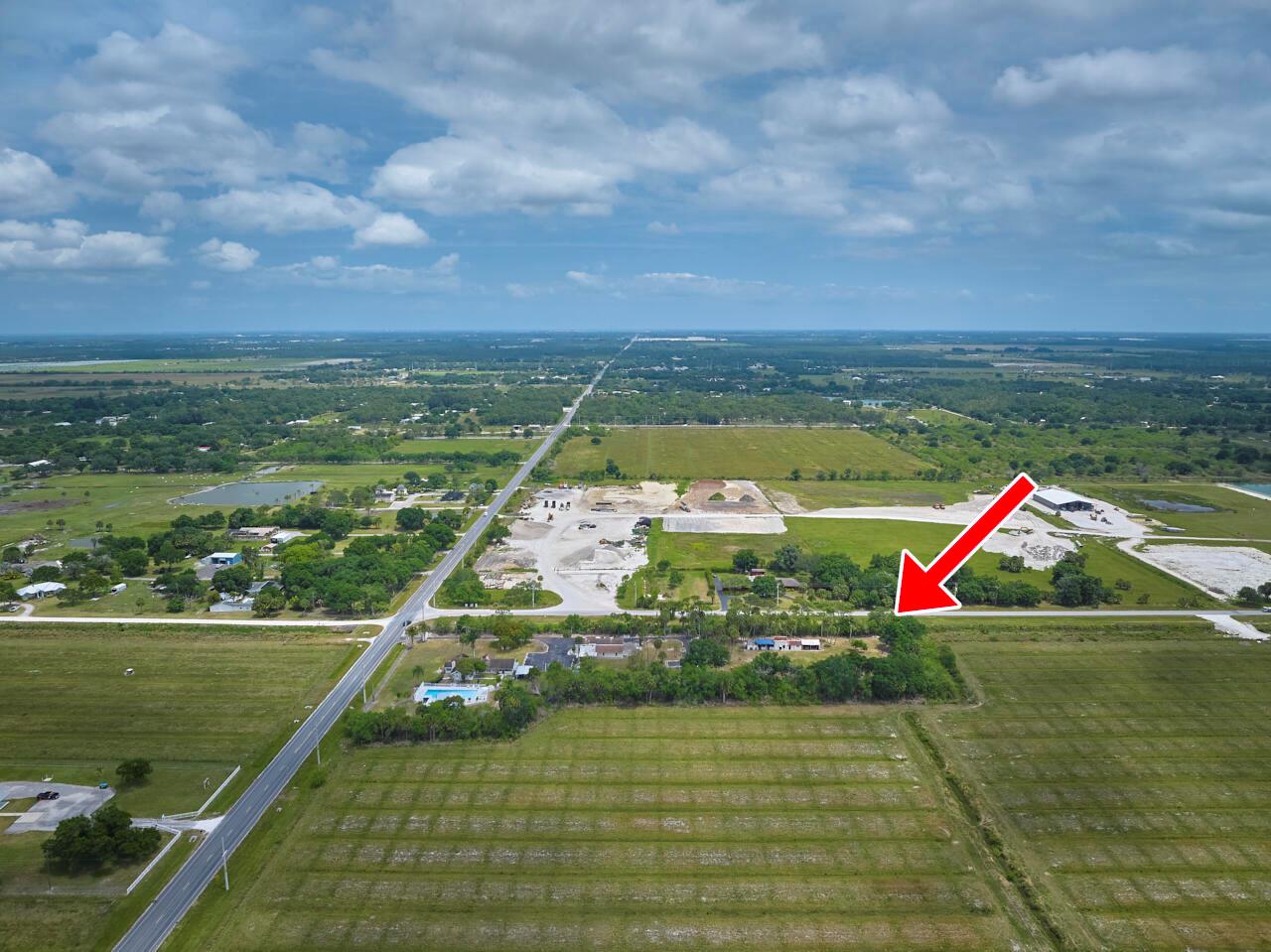 An aerial view shows a rural property with a house surrounded by trees and fields — 14601 Orange Avenue, Fort Pierce FL 34945, FORT PIERCE, FL