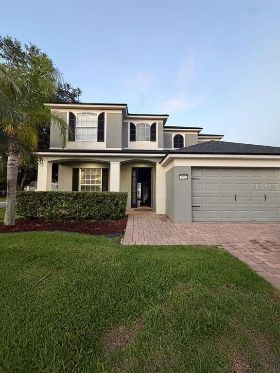 A two-story house with a gray exterior, a paved driveway, and a front hedge — 1105 TOLUKE POINT, ORLANDO, FL