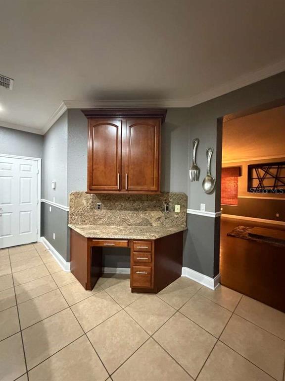 A kitchen desk area features wood cabinets, a granite countertop, and tile flooring — 1105 TOLUKE POINT, ORLANDO, FL