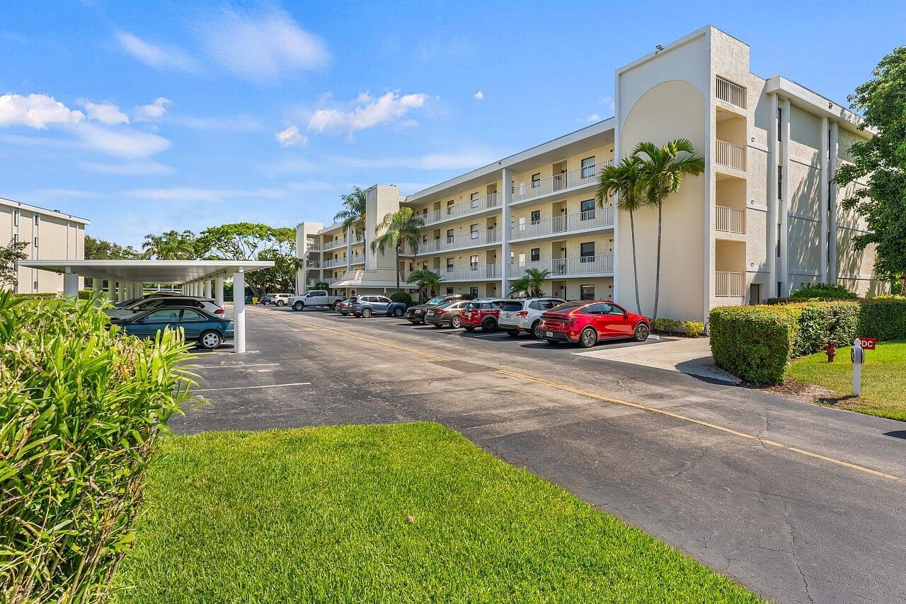 A multi-story apartment building with a parking lot and covered parking spaces in front — 300 N Highway A1a # 203c, Jupiter FL 33477, JUPITER, FL