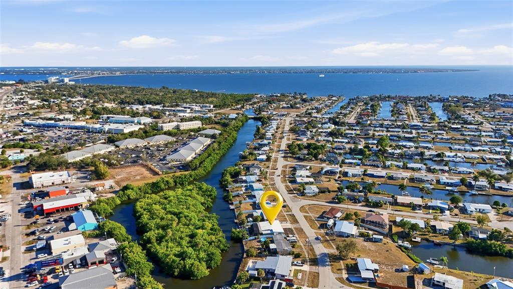 An aerial view shows a residential neighborhood with a canal and a yellow location pin — 4086 GARDNER DRIVE, PORT CHARLOTTE, FL