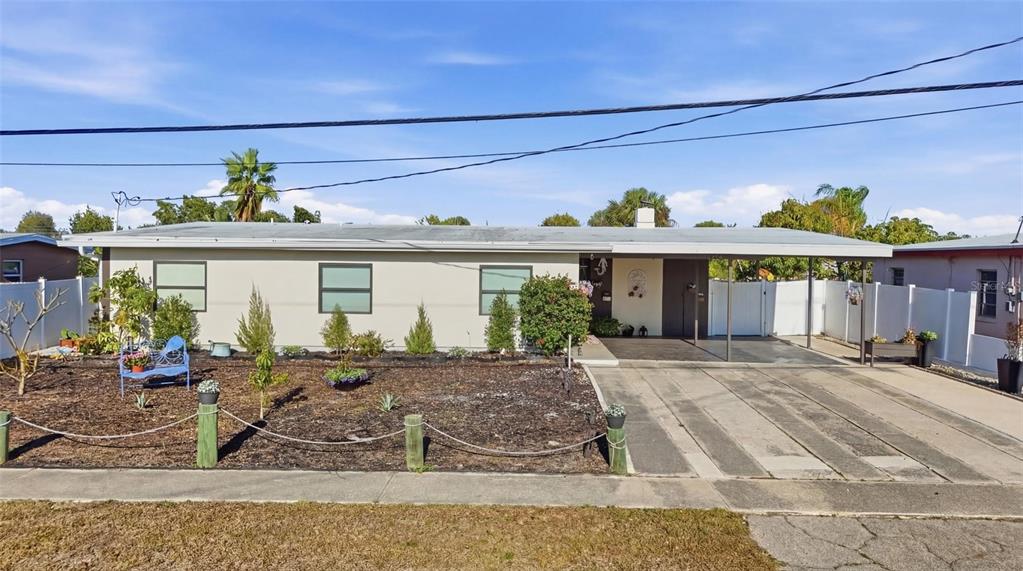 A single-story house with a carport, a front yard with mulch, and a rope fence — 4086 GARDNER DRIVE, PORT CHARLOTTE, FL