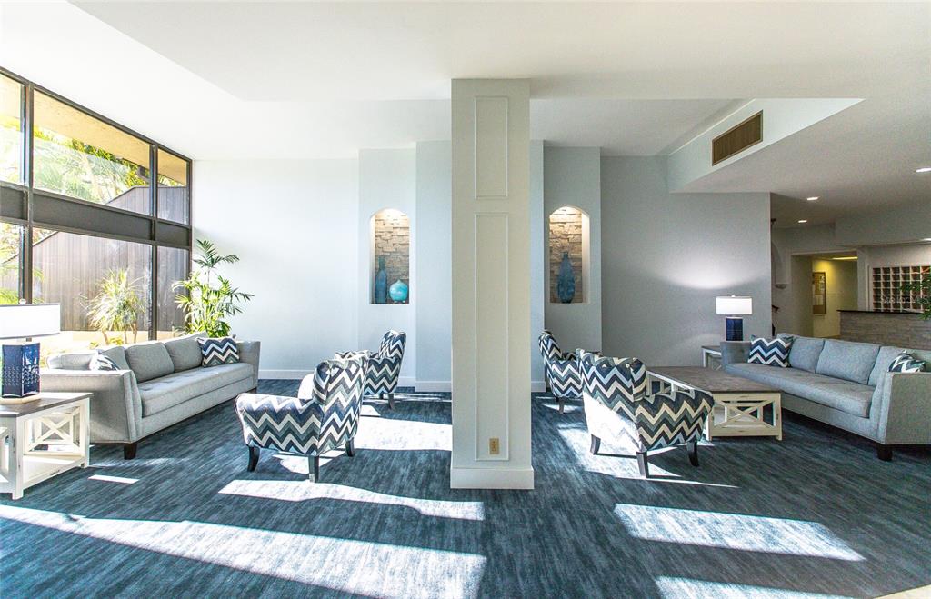A lobby features two gray sofas, patterned armchairs, and a central column with recessed niches — 5855 MIDNIGHT PASS ROAD UNIT 333, SARASOTA, FL