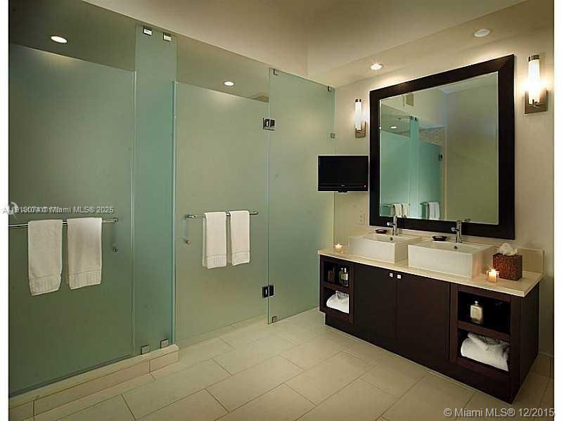 A modern bathroom features a double vanity, frosted glass shower doors, and light tile flooring — 5300 NW 87th Ave # 802, Doral FL 33178, DORAL, FL