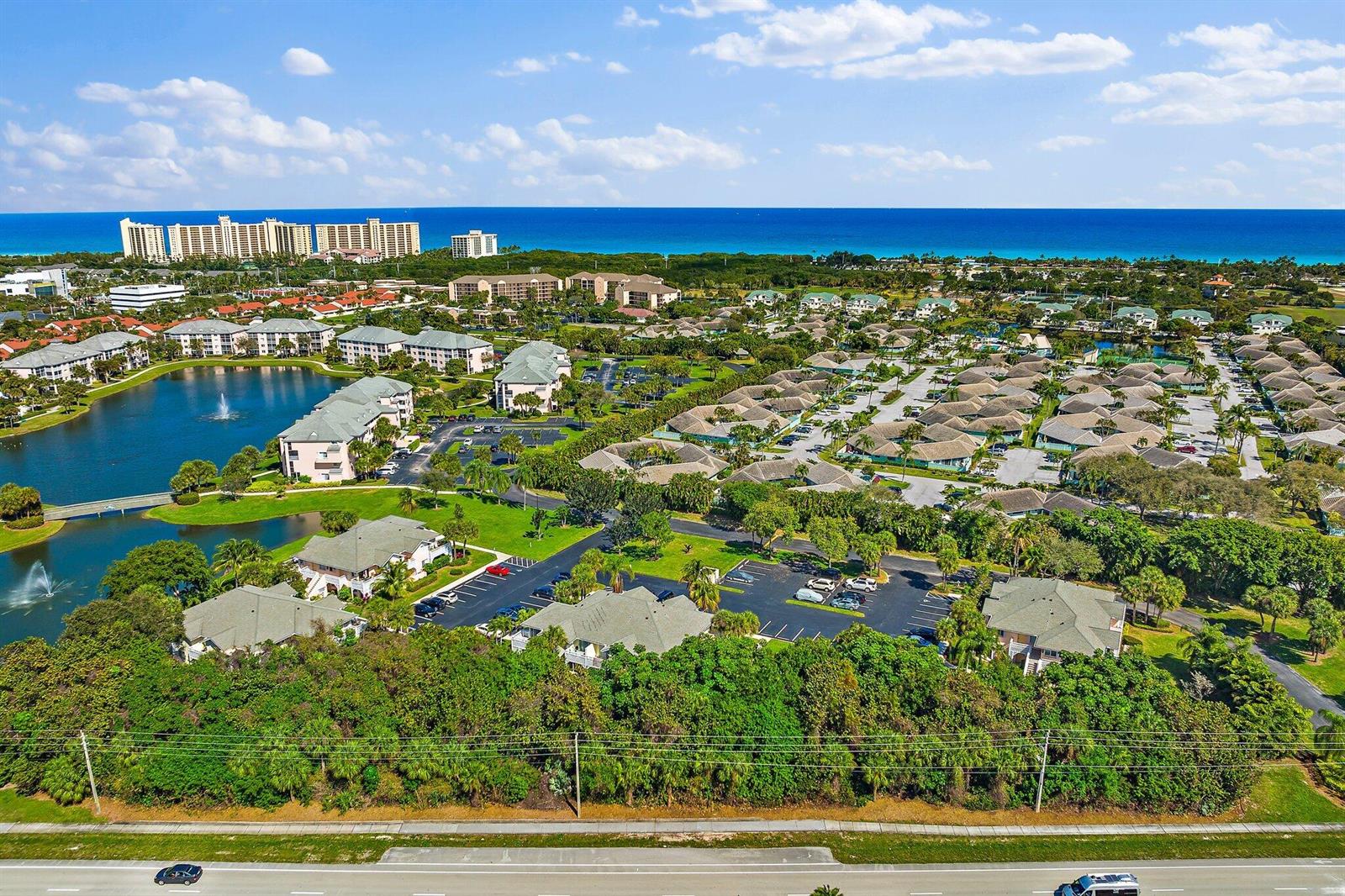 An aerial view of a residential community with a lake, green spaces, and the ocean — 353 S Us Highway 1 # C203, Jupiter FL 33477, JUPITER, FL